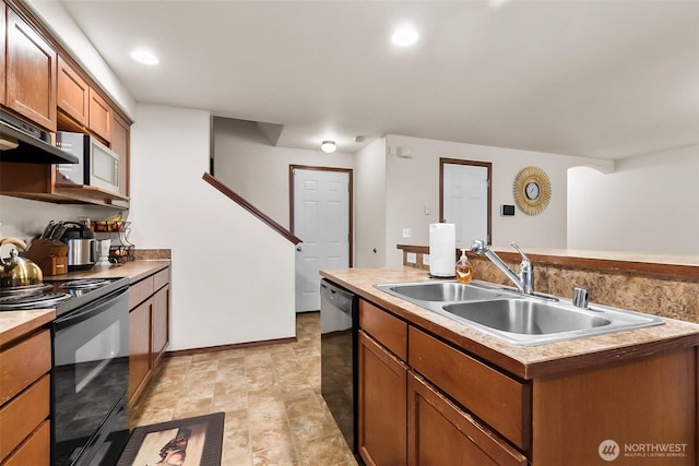 kitchen featuring recessed lighting, a sink, light countertops, black appliances, and brown cabinetry