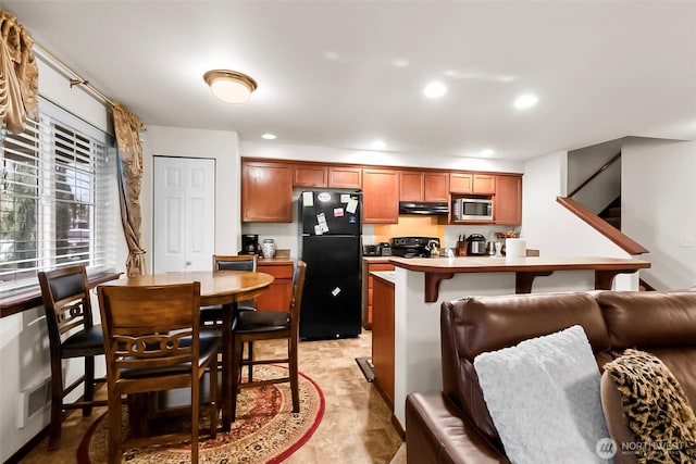 kitchen with black appliances, brown cabinets, light countertops, and recessed lighting