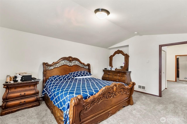 bedroom with vaulted ceiling, carpet flooring, visible vents, and baseboards