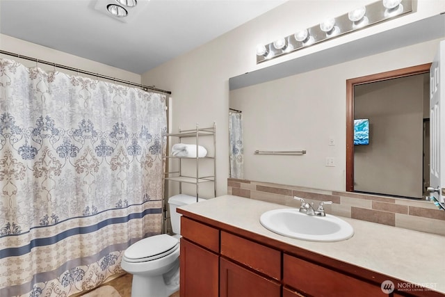 bathroom with toilet, backsplash, and vanity