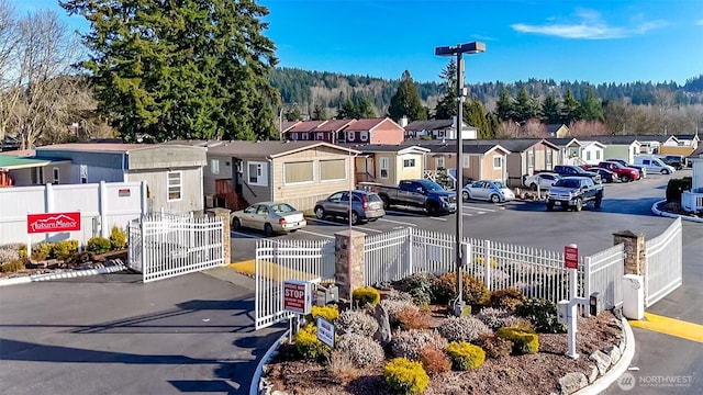 view of street featuring street lighting, a residential view, a gated entry, and curbs