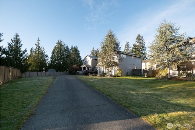 view of property exterior featuring fence and a yard