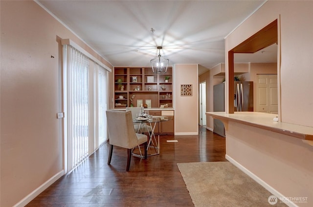 dining space with dark wood-style floors, plenty of natural light, baseboards, and a notable chandelier