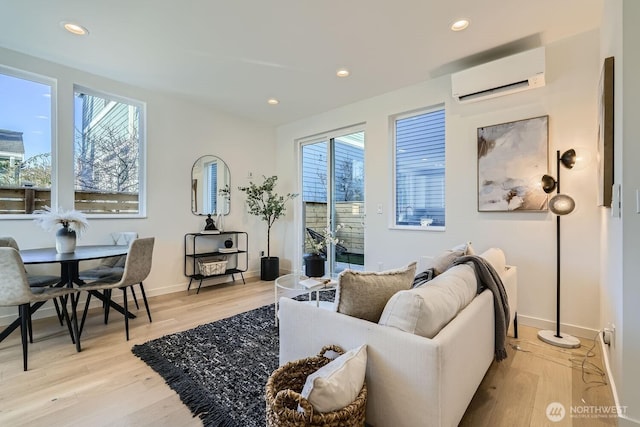 living room featuring light wood-style floors, an AC wall unit, and recessed lighting