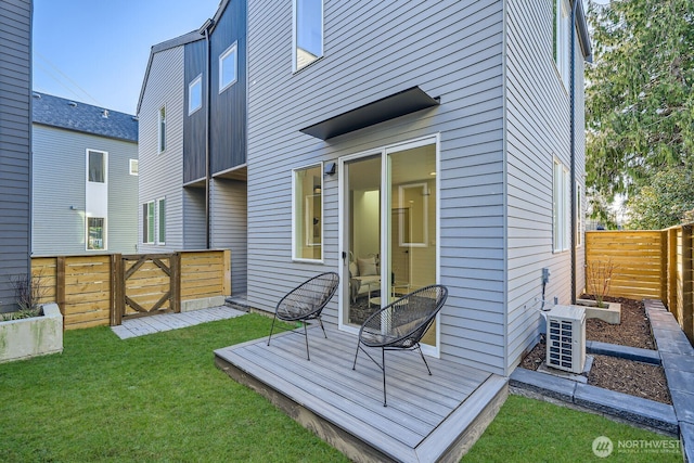 back of property featuring a yard, a fenced backyard, and a wooden deck