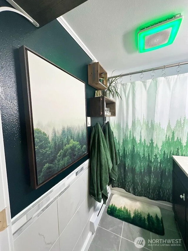 interior space with curtained shower, tile patterned flooring, a textured ceiling, and vanity