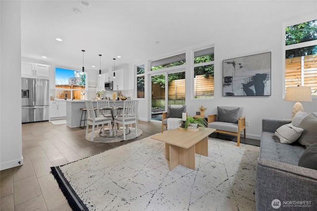 living room featuring baseboards, light wood-style floors, and recessed lighting