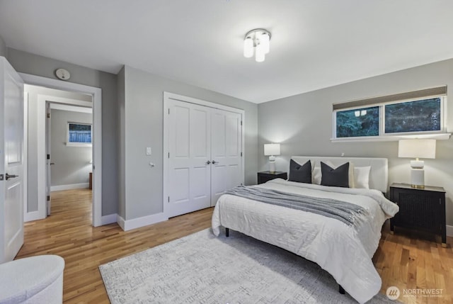 bedroom featuring baseboards, a closet, and light wood-style floors