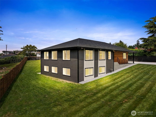 rear view of property with a yard and fence