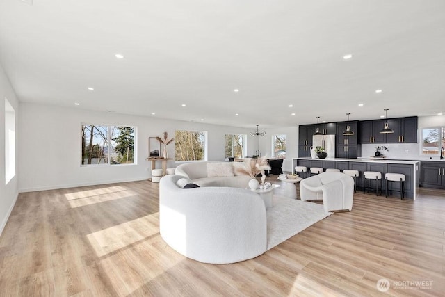 living room featuring light wood finished floors, baseboards, and recessed lighting