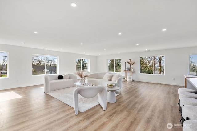 living room with light wood-type flooring, baseboards, and recessed lighting