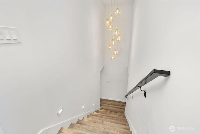 stairway with wood finished floors and baseboards