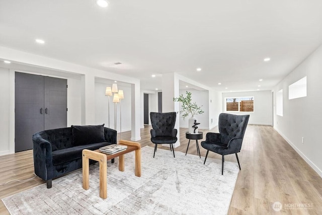 living room with recessed lighting, light wood-style flooring, and baseboards