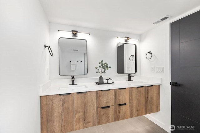 bathroom featuring tile patterned floors, visible vents, a sink, and double vanity