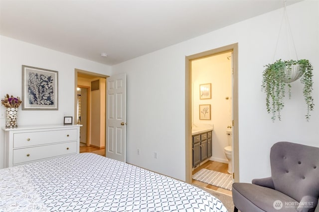 bedroom with ensuite bathroom and visible vents