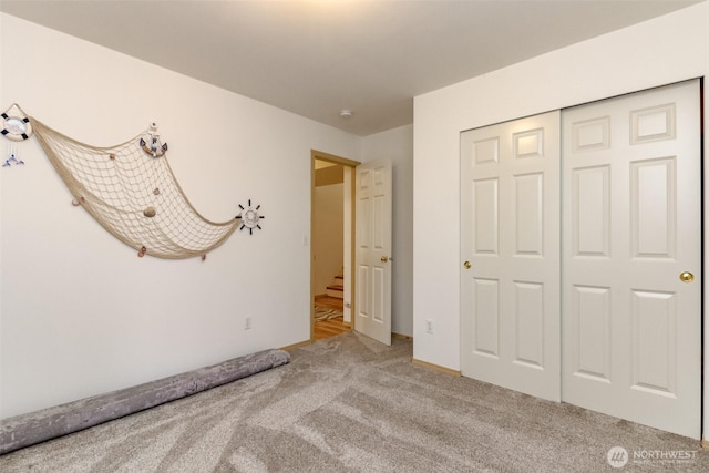 unfurnished bedroom featuring carpet and a closet