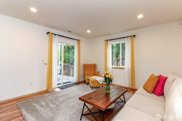 living area featuring a wealth of natural light, wood finished floors, and recessed lighting