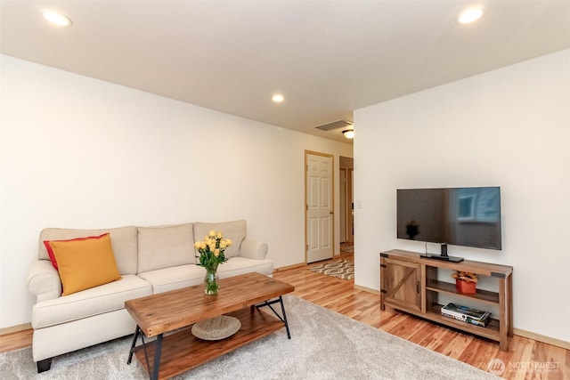 living area featuring baseboards, recessed lighting, visible vents, and light wood-style floors