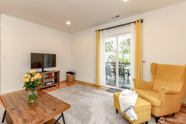 living area featuring recessed lighting, visible vents, baseboards, and wood finished floors