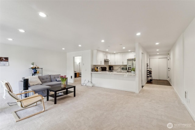 living room featuring light carpet, recessed lighting, and baseboards