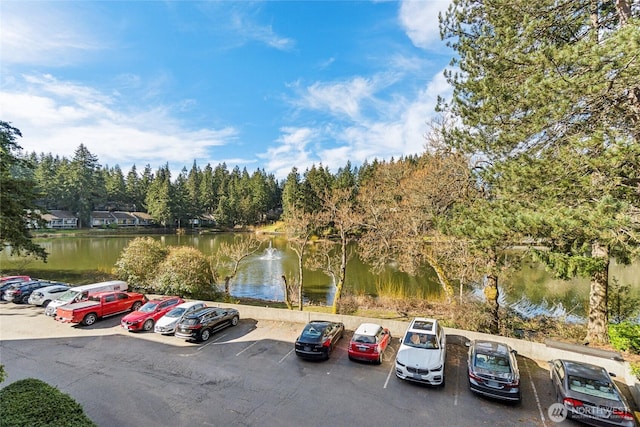 uncovered parking lot featuring a water view