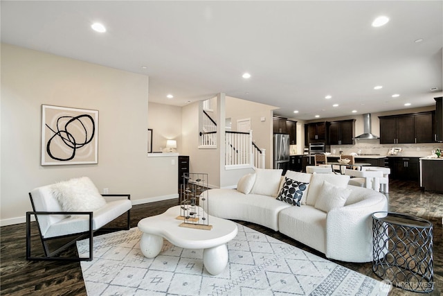 living area with baseboards, stairway, wood finished floors, and recessed lighting