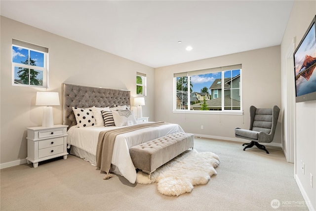 bedroom with baseboards and light colored carpet