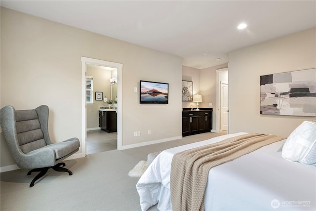 bedroom featuring recessed lighting, baseboards, ensuite bathroom, and light colored carpet