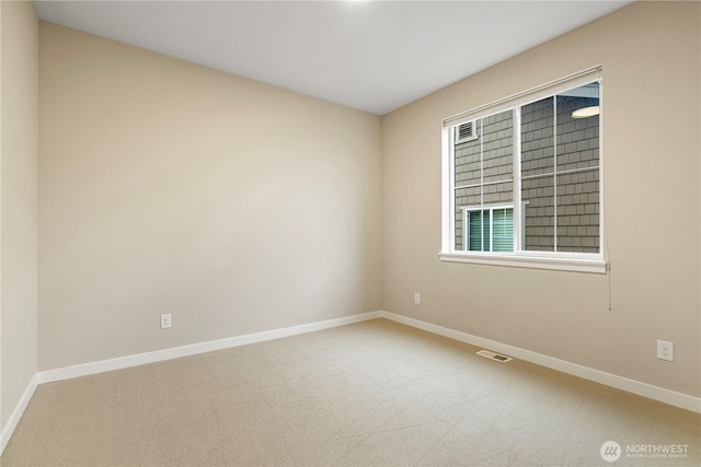 spare room featuring carpet, visible vents, and baseboards