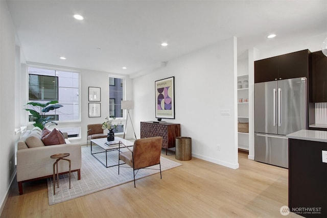 living room with baseboards, light wood-style flooring, and recessed lighting