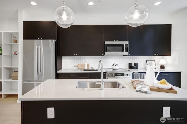 kitchen featuring stainless steel appliances, a sink, and light countertops