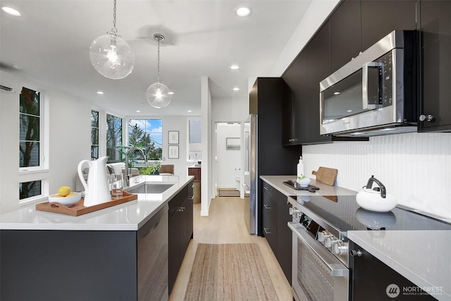 kitchen with dark cabinets, modern cabinets, stainless steel appliances, and a sink