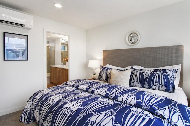 carpeted bedroom featuring ensuite bathroom, a wall mounted AC, recessed lighting, and baseboards