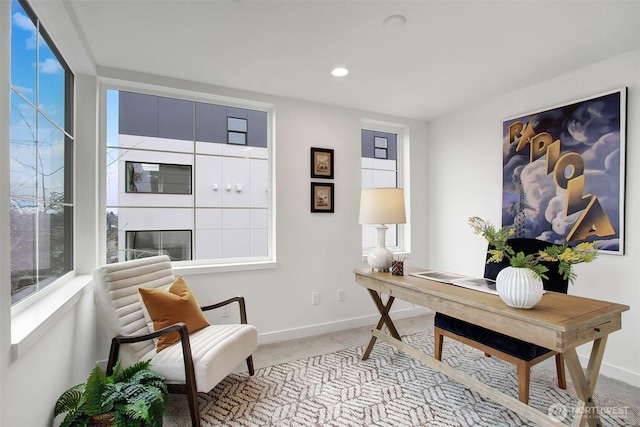 office area featuring light carpet, recessed lighting, a glass covered fireplace, and baseboards