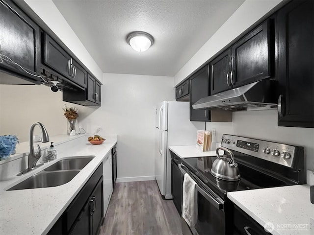 kitchen with a sink, dark cabinets, a textured ceiling, stainless steel range with electric stovetop, and under cabinet range hood