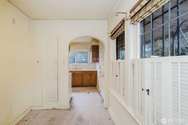 bathroom featuring baseboards, vanity, ornamental molding, and tile patterned floors