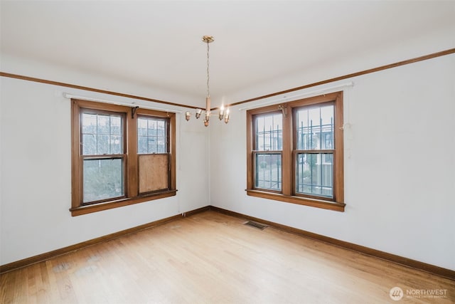 unfurnished room with a healthy amount of sunlight, visible vents, light wood-style flooring, and baseboards