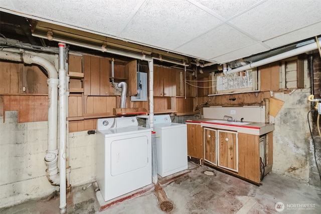 laundry area featuring a sink, washing machine and clothes dryer, and cabinet space