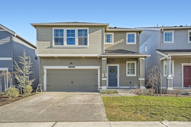 view of front of property featuring a garage, concrete driveway, and a front lawn