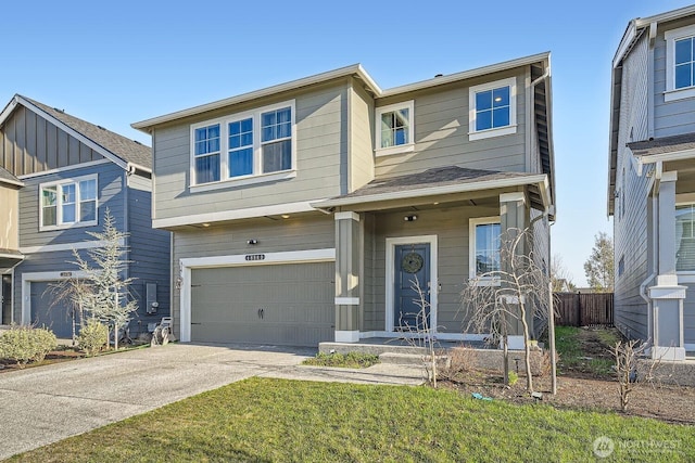 view of front facade with an attached garage, fence, and concrete driveway