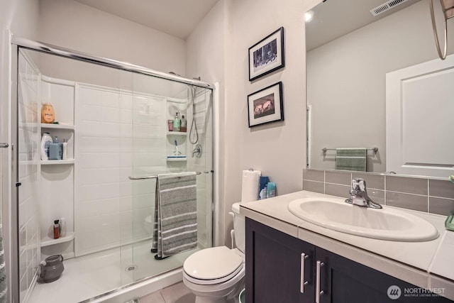 full bathroom featuring tasteful backsplash, a stall shower, vanity, and toilet