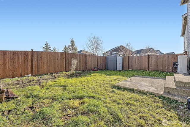 view of yard featuring a fenced backyard, a storage unit, and an outdoor structure