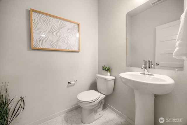 bathroom featuring visible vents, baseboards, toilet, marble finish floor, and a sink