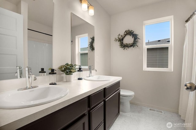 bathroom with toilet, baseboards, visible vents, and a sink