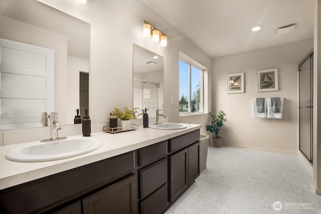 full bathroom with a sink, baseboards, a stall shower, and double vanity