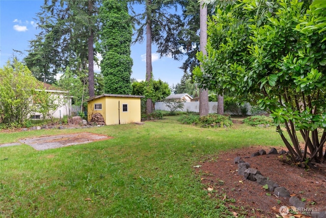 view of yard with an outbuilding, fence, and a storage unit