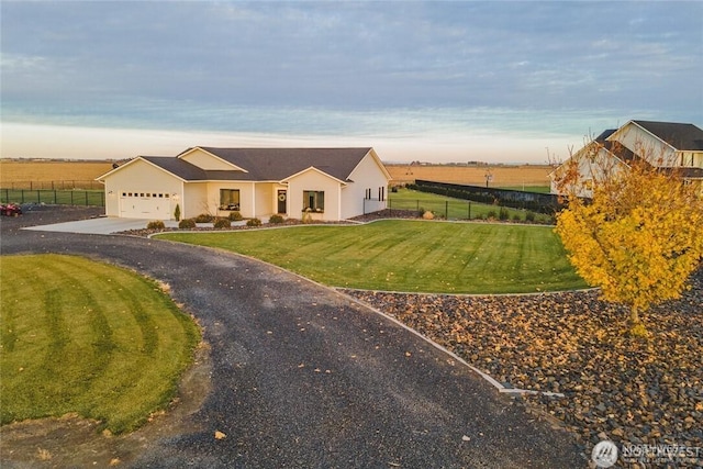 view of front facade with a garage, a front yard, fence, and driveway