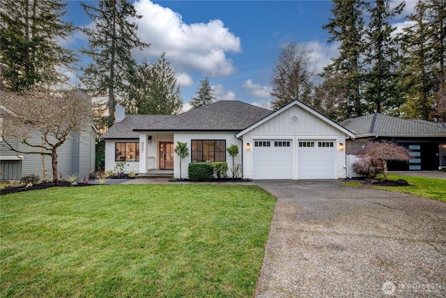 view of front of house with a garage, aphalt driveway, board and batten siding, and a front yard