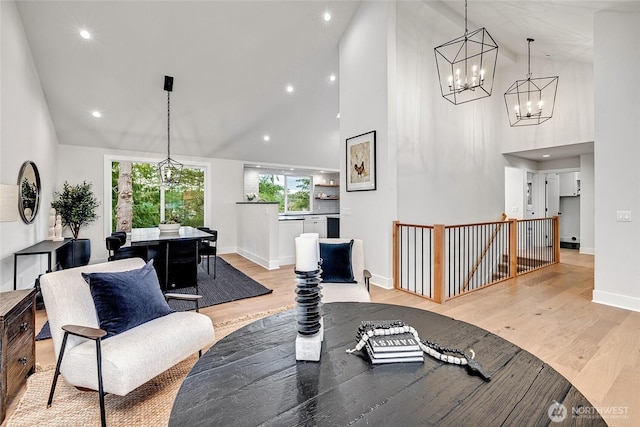 living room with high vaulted ceiling, recessed lighting, light wood-style flooring, and baseboards