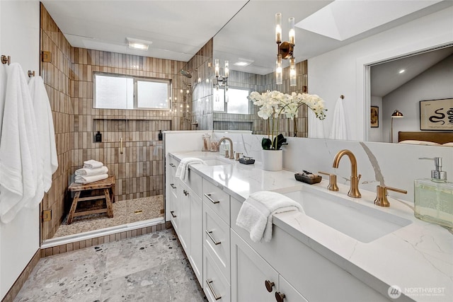 bathroom featuring a walk in shower, double vanity, and a sink